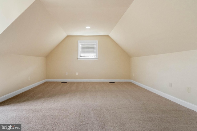 additional living space featuring carpet and lofted ceiling