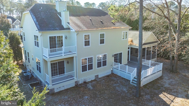 rear view of house with a deck and a sunroom