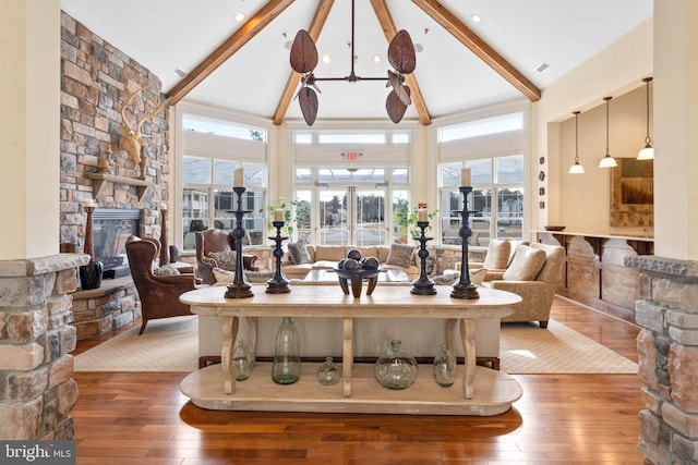 living room featuring a fireplace, beam ceiling, wood-type flooring, and high vaulted ceiling