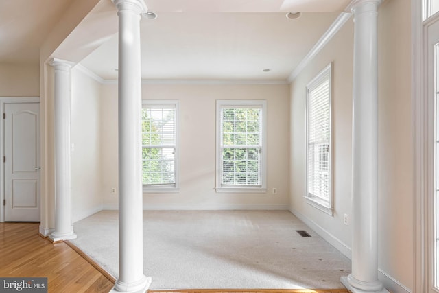 interior space with crown molding and ornate columns