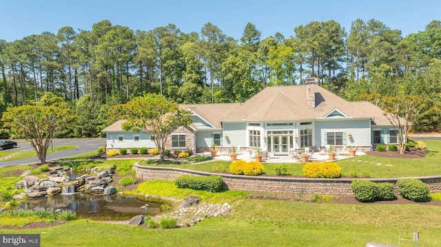 back of house featuring a lawn, french doors, and a patio