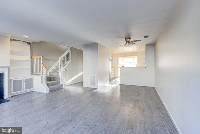 unfurnished living room featuring ceiling fan and hardwood / wood-style floors