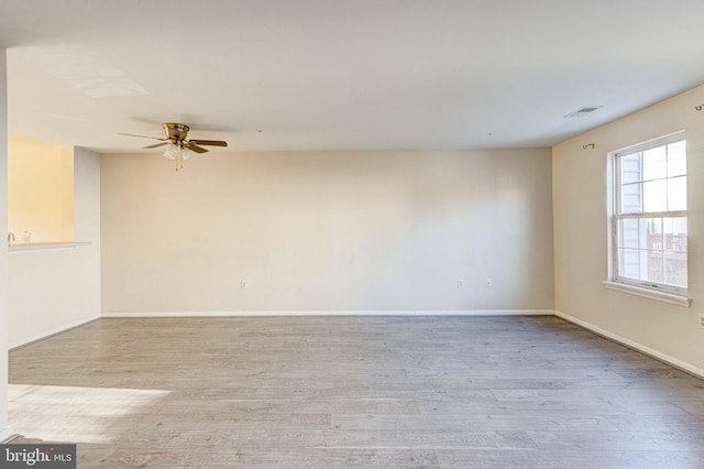 spare room featuring ceiling fan and light hardwood / wood-style flooring