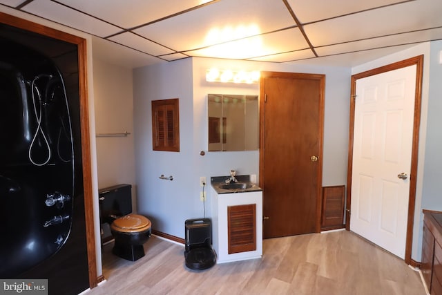 bathroom featuring sink, wood-type flooring, toilet, and a drop ceiling