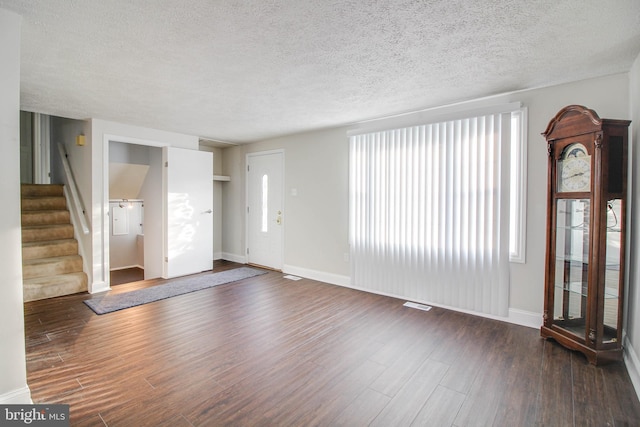 interior space featuring dark wood-type flooring and a textured ceiling