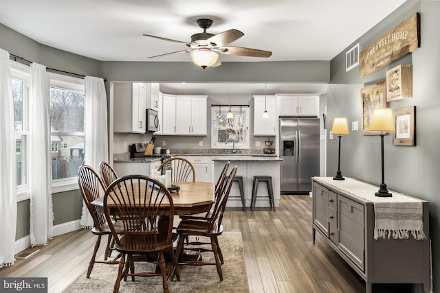 dining area featuring hardwood / wood-style flooring and ceiling fan