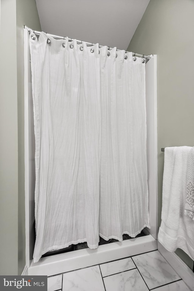 bathroom featuring lofted ceiling and a shower with curtain