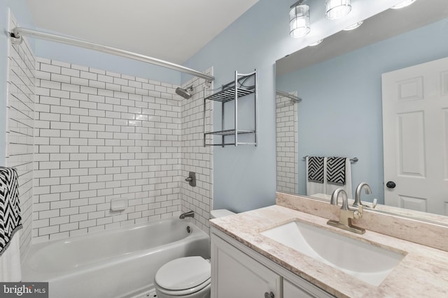 full bathroom featuring toilet, tiled shower / bath, and vanity