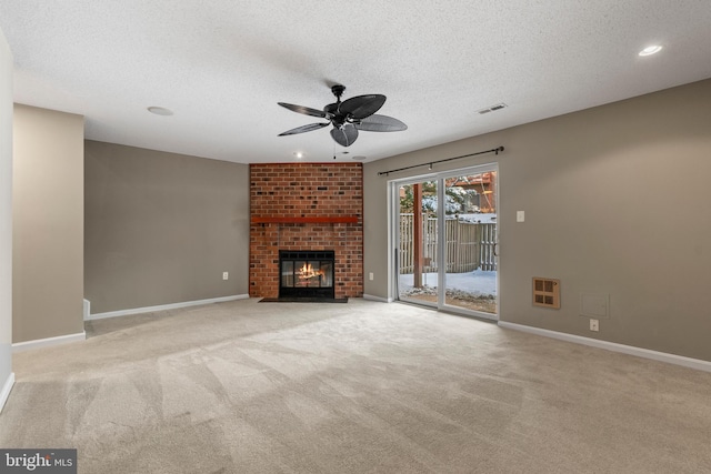 unfurnished living room featuring ceiling fan, a fireplace, heating unit, a textured ceiling, and light carpet