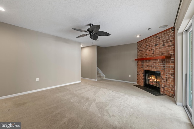 unfurnished living room with a brick fireplace, light colored carpet, a textured ceiling, and ceiling fan