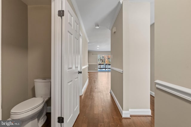 bathroom featuring toilet, crown molding, and hardwood / wood-style flooring