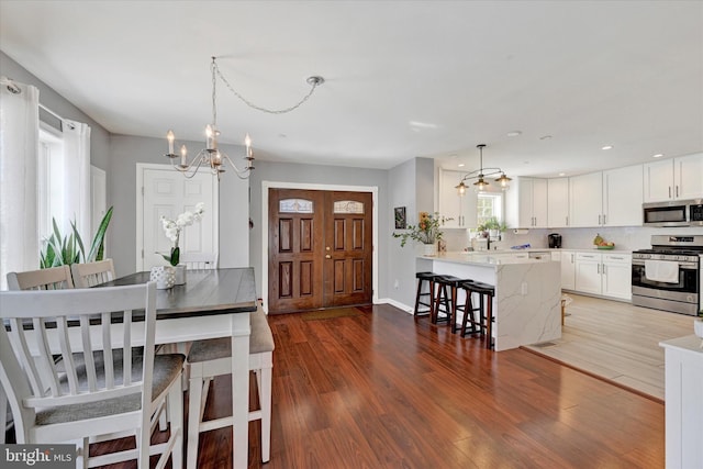 kitchen featuring a breakfast bar, white cabinetry, tasteful backsplash, kitchen peninsula, and stainless steel appliances