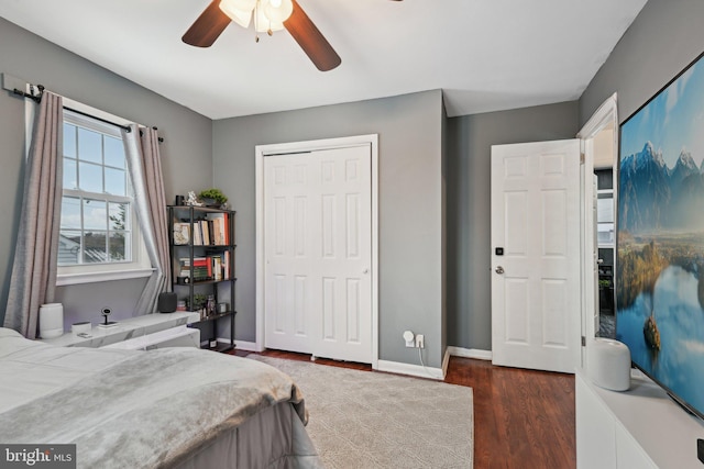 bedroom with dark wood-type flooring, a closet, and ceiling fan