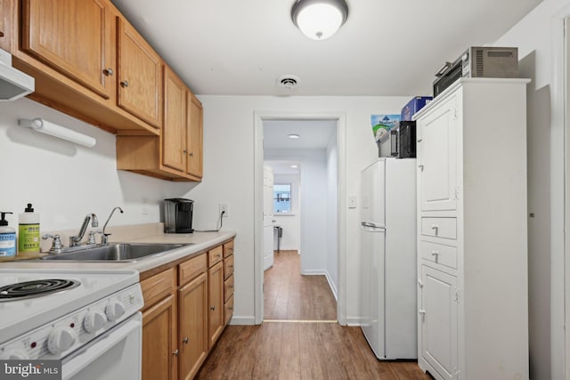 kitchen featuring sink, white appliances, and light hardwood / wood-style floors