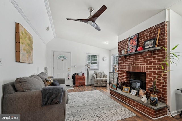 living room with a fireplace, wood-type flooring, ceiling fan, and vaulted ceiling