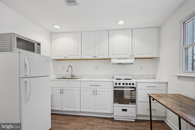 kitchen with sink, white appliances, white cabinets, and dark hardwood / wood-style flooring