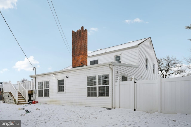 view of snow covered back of property