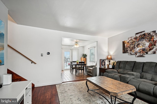 living room featuring ceiling fan and dark hardwood / wood-style floors