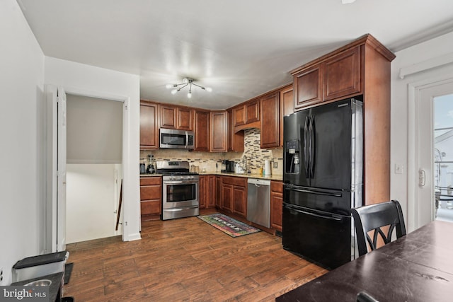 kitchen with dark wood-type flooring, sink, stainless steel appliances, and tasteful backsplash