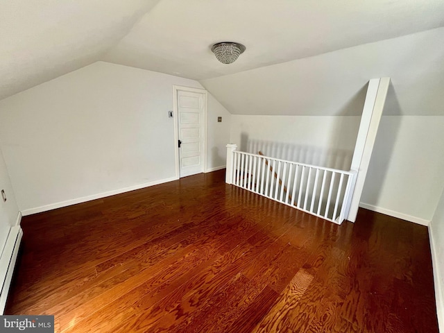 additional living space with hardwood / wood-style flooring, a baseboard heating unit, and vaulted ceiling