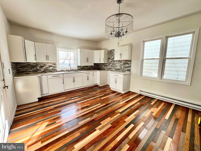 kitchen with white cabinetry, tasteful backsplash, an inviting chandelier, sink, and hanging light fixtures