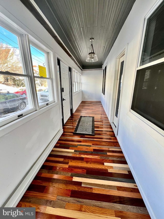 hall with dark hardwood / wood-style flooring and wood ceiling