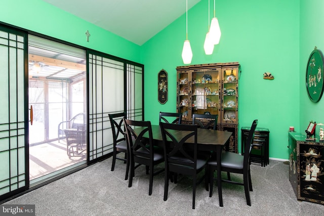 carpeted dining room with vaulted ceiling