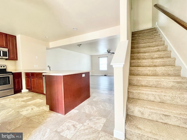 kitchen with sink, stainless steel appliances, ceiling fan, and kitchen peninsula