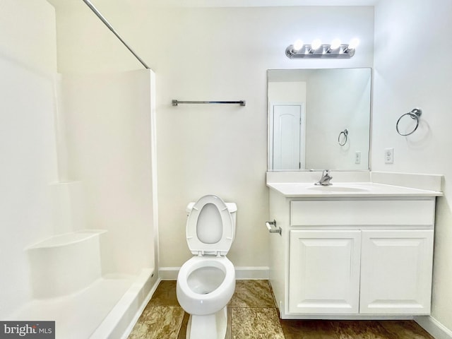 bathroom with vanity, toilet, and a shower