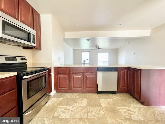 kitchen with sink, stainless steel appliances, ceiling fan, and kitchen peninsula