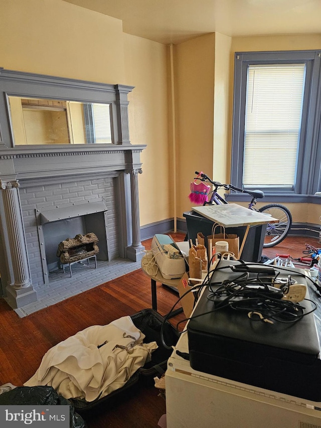 living room featuring a brick fireplace and hardwood / wood-style floors