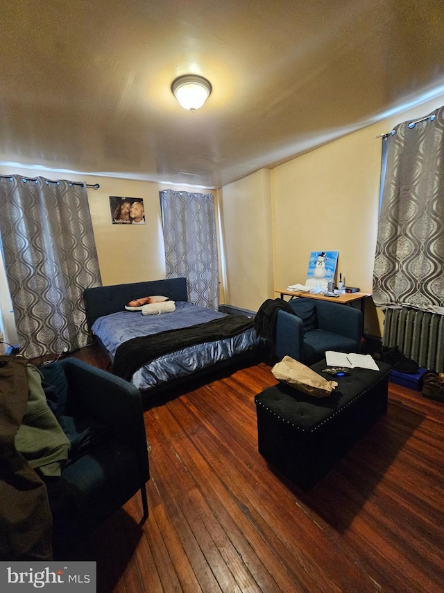 bedroom featuring radiator and hardwood / wood-style floors