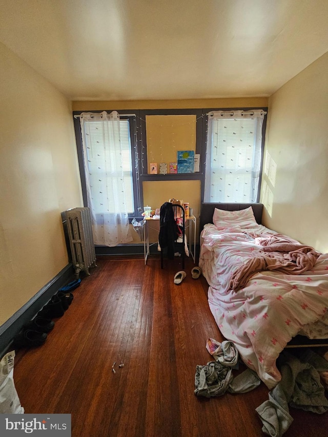 bedroom featuring radiator and dark hardwood / wood-style flooring