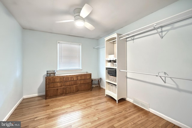 spacious closet featuring visible vents, light wood-style floors, and ceiling fan