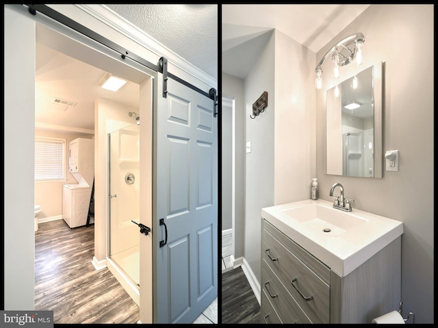 bathroom with visible vents, wood finished floors, a stall shower, and vanity