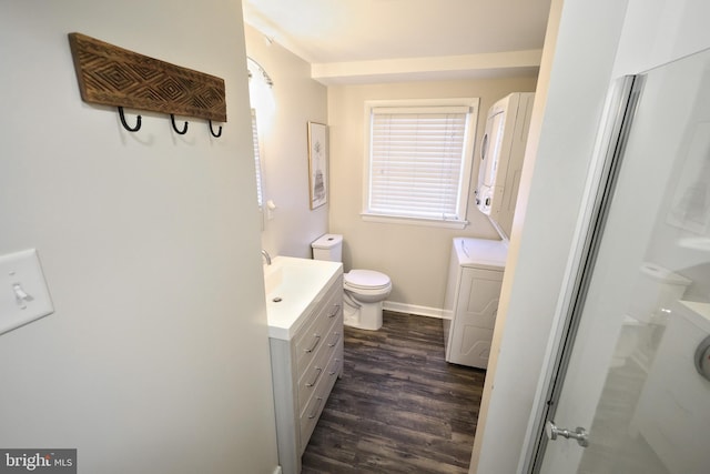 full bath featuring vanity, wood finished floors, baseboards, walk in shower, and toilet