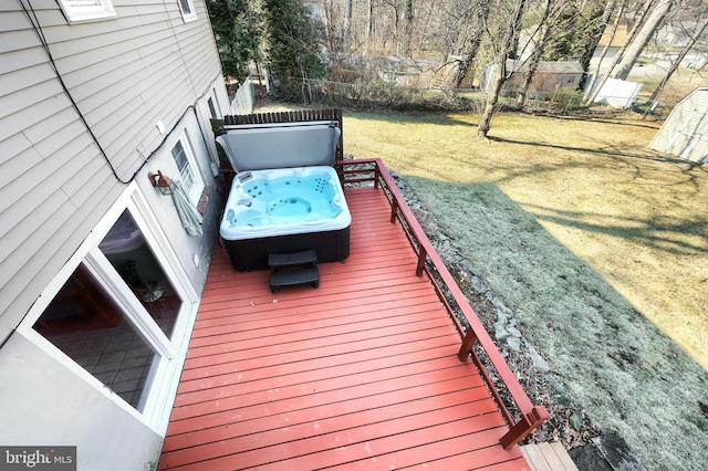 deck featuring a lawn, a hot tub, and fence