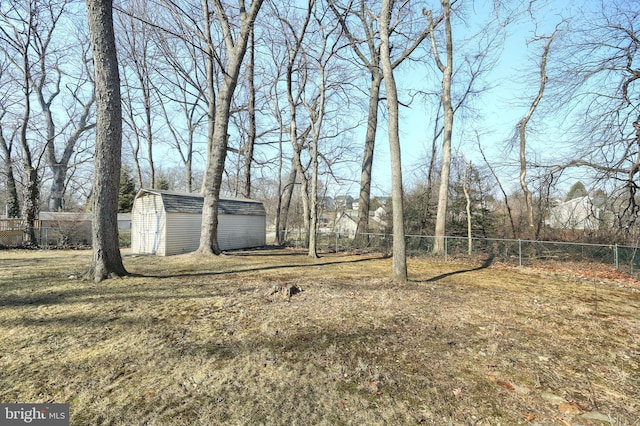 view of yard with an outbuilding, a storage unit, and a fenced backyard