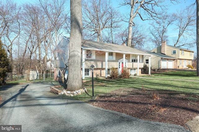 view of front of property featuring driveway, a chimney, and a front yard