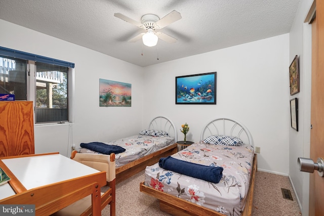 carpeted bedroom with a textured ceiling and ceiling fan