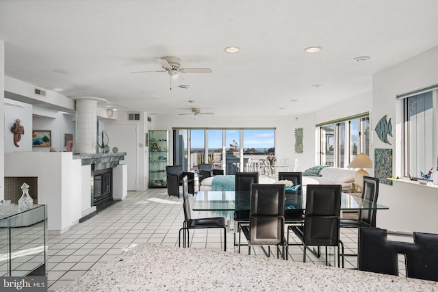 tiled dining area featuring a large fireplace and ornate columns