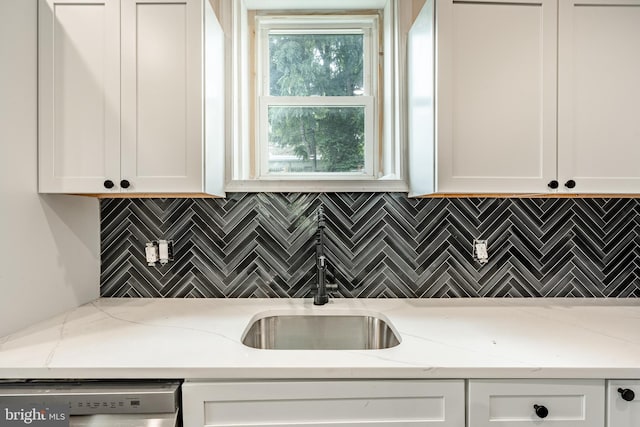 kitchen featuring light stone countertops, white cabinetry, and dishwasher