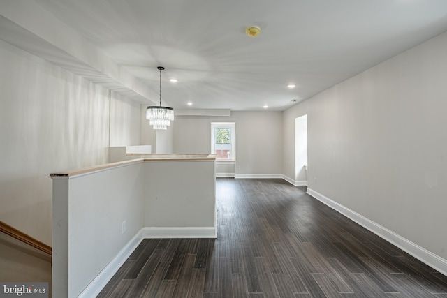 unfurnished room featuring a chandelier and dark hardwood / wood-style flooring