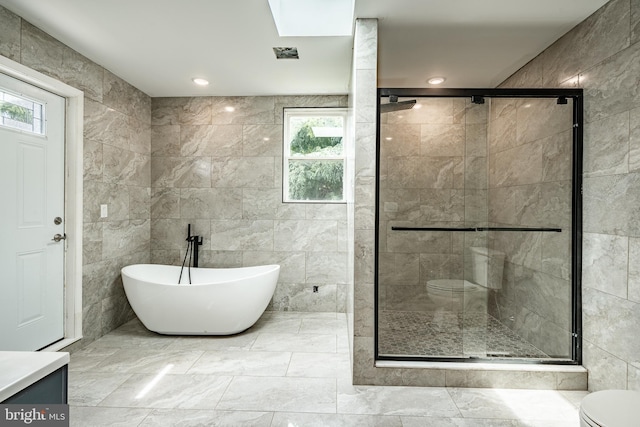 bathroom featuring plenty of natural light and tile walls