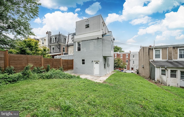 rear view of property featuring a lawn