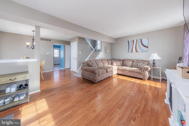 living room with hardwood / wood-style floors and a chandelier