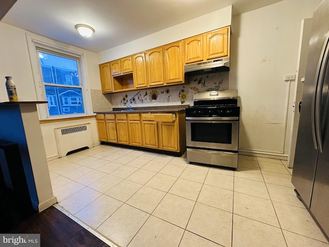 kitchen featuring radiator, light tile patterned floors, appliances with stainless steel finishes, and backsplash