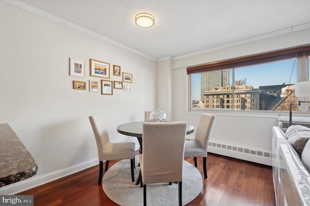 dining area featuring a textured ceiling, baseboard heating, ornamental molding, and dark hardwood / wood-style floors