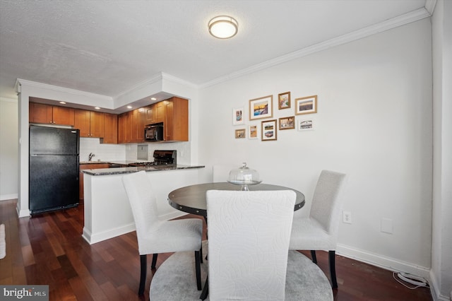 dining space featuring dark wood-type flooring, a textured ceiling, and crown molding