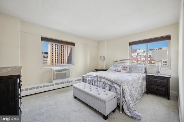 carpeted bedroom featuring a baseboard heating unit and a wall mounted air conditioner